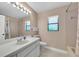 Well-lit bathroom featuring a white vanity, neutral tile, and a window for natural light at 1996 Promenade Way, Clearwater, FL 33760