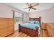 Cozy bedroom with a wooden bed frame, ceiling fan, and a window offering natural light at 1996 Promenade Way, Clearwater, FL 33760