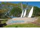 Seabrooke community sign with view of the pond and mature trees on a sunny day at 1996 Promenade Way, Clearwater, FL 33760