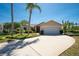 Charming single-story home with well-manicured lawn, palm trees, and a spacious driveway to the two-car garage at 1996 Promenade Way, Clearwater, FL 33760