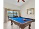 Bright game room with blue billiards table and view of the backyard swimming pool at 1996 Promenade Way, Clearwater, FL 33760