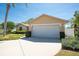 Front exterior showing a two car garage with a well manicured front yard at 1996 Promenade Way, Clearwater, FL 33760