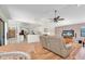 Open-concept living room boasts comfortable seating, wood floors, and access to the kitchen and dining area at 1996 Promenade Way, Clearwater, FL 33760
