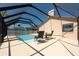 Relaxing screened-in pool area with lounge chairs, an inviting water feature, and manicured landscaping at 1996 Promenade Way, Clearwater, FL 33760