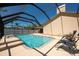 Relaxing screened-in pool area with lounge chairs and a refreshing water feature with manicured landscaping at 1996 Promenade Way, Clearwater, FL 33760