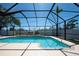 Enclosed pool with clear blue water, lush landscaping and a screen enclosure with plenty of light at 1996 Promenade Way, Clearwater, FL 33760
