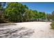 Sand volleyball court surrounded by trees, offering recreational opportunities at 1996 Promenade Way, Clearwater, FL 33760