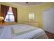 Bedroom featuring yellow walls, wood floors, and a window that lets in natural light at 221 Shell Falls Dr, Apollo Beach, FL 33572