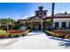 Beautiful clubhouse exterior with manicured landscaping, concrete walkway, and benches on a bright, sunny day at 221 Shell Falls Dr, Apollo Beach, FL 33572