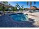 Inviting hot tub surrounded by lounge seating with umbrellas and tropical foliage at 221 Shell Falls Dr, Apollo Beach, FL 33572