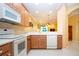 Kitchen with wood cabinets and white appliances offering a view into the living room at 221 Shell Falls Dr, Apollo Beach, FL 33572