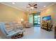 Bright living room with a ceiling fan, slider door, and media center with television at 221 Shell Falls Dr, Apollo Beach, FL 33572