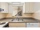Functional kitchen with a double sink, white cabinets, and dishwasher at 250 Nw Rosery Rd # 314, Largo, FL 33770