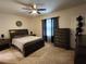 Bedroom with a dark wood frame bed, ceiling fan, and matching furniture at 3267 Pleasant Willow Ct, Brandon, FL 33511