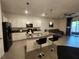 This modern kitchen has an island with granite countertops, stainless appliances, and easy access to living area at 3267 Pleasant Willow Ct, Brandon, FL 33511