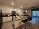 Open-concept kitchen featuring granite countertops, stainless appliances, pendant lights, and a seamless transition to the living area at 3267 Pleasant Willow Ct, Brandon, FL 33511