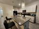 This kitchen has an island with a granite countertop, stainless steel appliances, and modern pendant lighting at 3267 Pleasant Willow Ct, Brandon, FL 33511