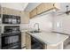 Cozy kitchen space showcases modern appliances, dark cooktop and microwave, and a stainless steel sink at 3318 Peterborough Pl, Palm Harbor, FL 34684