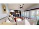 Cozy living room with a fireplace, ceiling fan, and access to the outdoor pool area at 3639 Darston St, Palm Harbor, FL 34685