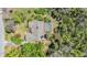 Overhead shot displaying a home with a backyard swimming pool surrounded by lush, mature trees at 401 Apache Trl, Brandon, FL 33511