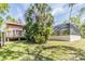 Backyard featuring lush greenery, a wooden deck, and a screened-in enclosure for outdoor enjoyment at 401 Apache Trl, Brandon, FL 33511