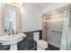 Well-lit bathroom featuring a pedestal sink, tiled walk-in shower, and stylish mirror at 401 Apache Trl, Brandon, FL 33511