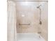 Modern bathroom featuring soaking tub and tile surround with shower head and safety bar at 401 Apache Trl, Brandon, FL 33511