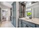 Bathroom features double sinks, stone counters, gray cabinets, and additional storage at 401 Apache Trl, Brandon, FL 33511
