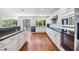 White kitchen features granite countertops, stainless steel appliances, and dark wood flooring at 401 Apache Trl, Brandon, FL 33511