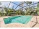 Inviting pool area surrounded by a screened-in enclosure and lush greenery for a tropical feel at 401 Apache Trl, Brandon, FL 33511