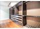 Spacious walk-in closet with custom shelving, drawers, and hardwood flooring at 401 Apache Trl, Brandon, FL 33511
