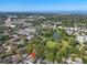 Aerial view of a home near a pond surrounded by lush trees and cityscape at 427 5Th Nw St, Largo, FL 33770