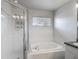 Bathroom with a shower featuring a glass door and large white tub at 4426 Brandon Ridge Dr, Valrico, FL 33594