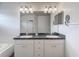 Bright bathroom featuring a double vanity with a dark countertop and modern light fixtures at 4426 Brandon Ridge Dr, Valrico, FL 33594