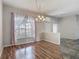Bright dining room with chandelier, wood floors, large window with curtains and entrance to kitchen at 4426 Brandon Ridge Dr, Valrico, FL 33594