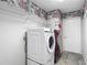 Bright laundry room featuring a modern washer and dryer, wire shelving, and eye-catching decorative wallpaper at 4426 Brandon Ridge Dr, Valrico, FL 33594