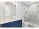 Bright bathroom with a frameless glass shower, navy blue vanity, and modern fixtures at 4614 W Lowell Ave, Tampa, FL 33629