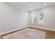 A light-filled bedroom with two windows, hardwood floors, and a patterned area rug at 4614 W Lowell Ave, Tampa, FL 33629
