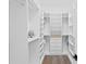 A modern, spacious closet with white shelving, drawers, and a plush gray teddy bear at 4614 W Lowell Ave, Tampa, FL 33629