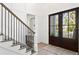 Inviting foyer with a staircase and dark wood double doors allowing plenty of natural light at 4614 W Lowell Ave, Tampa, FL 33629
