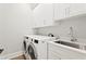 Functional laundry room with modern washer, dryer, sink, and plenty of cabinet space at 4614 W Lowell Ave, Tampa, FL 33629