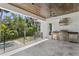 A covered outdoor kitchen with grill, sink, ceiling fans, and views of the lush backyard at 4614 W Lowell Ave, Tampa, FL 33629