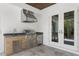 Outdoor kitchen featuring stainless steel appliances, a built-in grill, and a stylish countertop near double doors at 4614 W Lowell Ave, Tampa, FL 33629