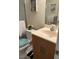 Well-lit bathroom with a light wood vanity, toilet, and shower behind glass doors at 5553 Baywater Dr, Tampa, FL 33615