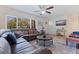 Spacious living room showcasing wood look tile, a comfortable sofa, ceiling fan, and a large window at 5601 4Th S St, St Petersburg, FL 33705