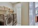 Modern laundry room with front load washer and dryer, plus shelving for storage at 5611 Eagleglen Pl, Lithia, FL 33547