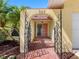 Inviting arched front entry with brick pathway and decorative wrought iron at 562 Johns Pass Ave, Madeira Beach, FL 33708