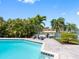 Refreshing pool with brick paver patio, lush landscaping, and waterfront views at 562 Johns Pass Ave, Madeira Beach, FL 33708