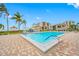 Beautiful pool surrounded by palm trees and luxurious lounge area with blue umbrellas and gulf views at 6357 Bahia Del Mar Blvd # 206, St Petersburg, FL 33715