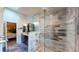 Modern bathroom with glass-enclosed shower, updated fixtures, marble flooring, and a separate vanity area at 64 Pelican Pl, Belleair, FL 33756